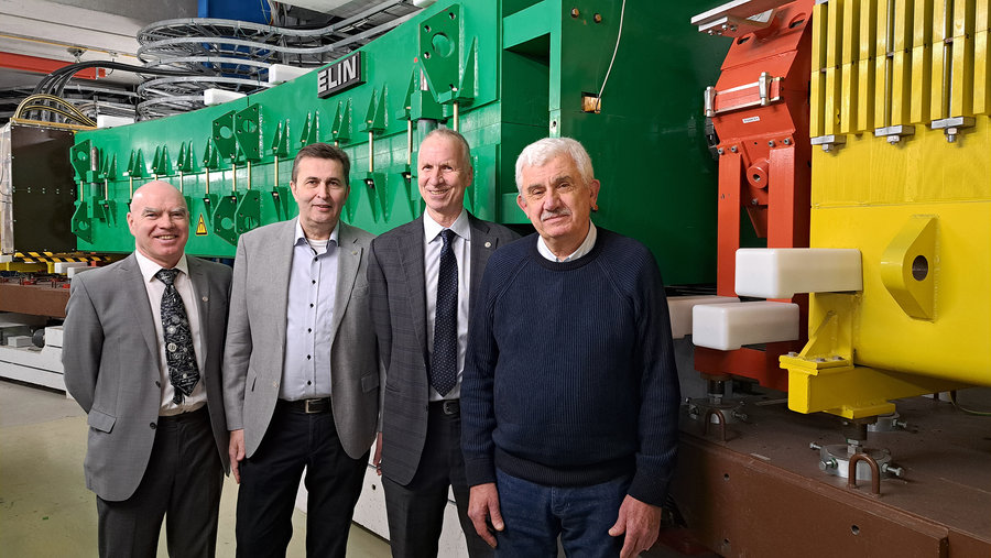 Entdecker der Kernisomere Vier Männer stehen vor einem grünen und einem gelben Magneten des GSI-Fragementseparators.