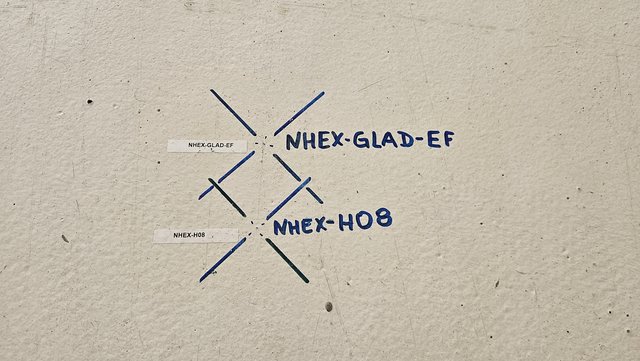 Two blue-line markings on the concrete floor of the High-Energy Cave. One of them, “NHEX-GLAD-EF” will be used to align/position the flange of the GLAD magnet (NHEX is the internal nomenclature for the functional location “NUSTAR-HEC-EXPERIMENT”) Two blue-line markings on the concrete floor of the High-Energy Cave. One of them, “NHEX-GLAD-EF” will be used to align/position the flange of the GLAD magnet (NHEX is the internal nomenclature for the functional location “NUSTAR-HEC-EXPERIMENT”)